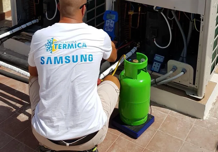 Technician with a gas cylinder beside a Samsung unit